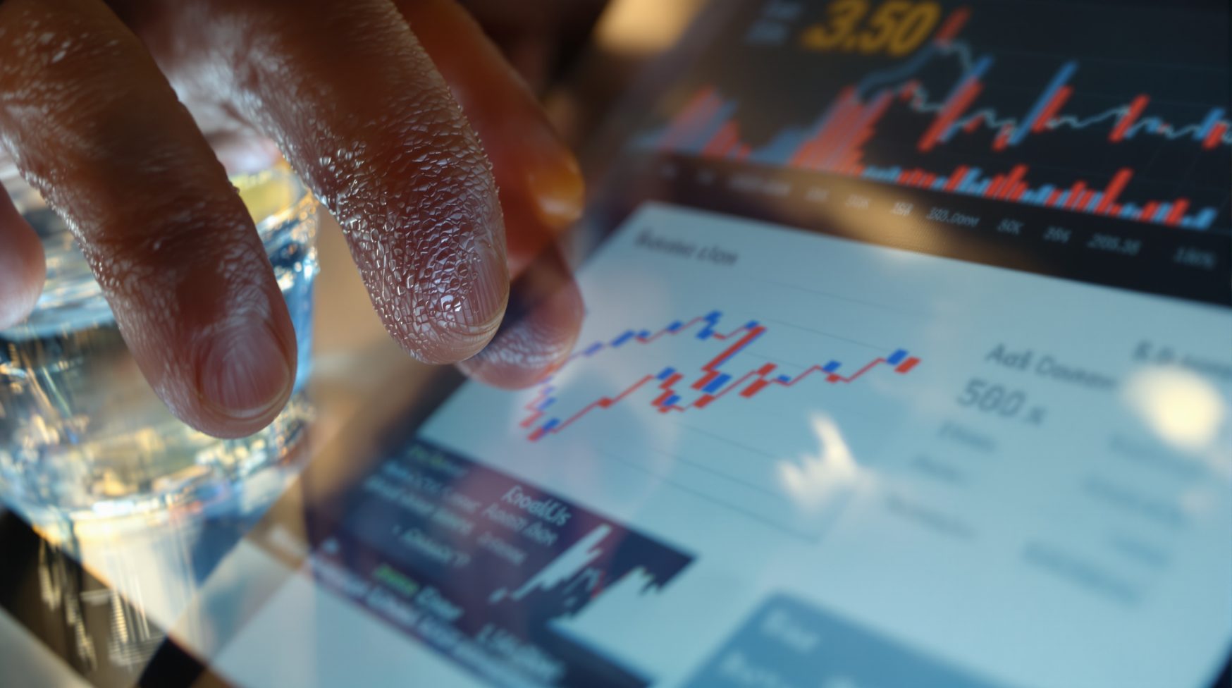 Close-up of hand over mouse with Ads Manager performance chart visible